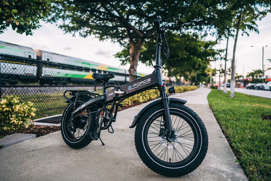 Compact foldable electric bike parked on an urban sidewalk, showcasing modern transportation.